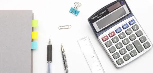 電卓とペン、付箋の付いたノート