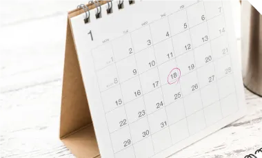 電卓とペン、付箋の付いたノート